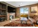 Living room with a fireplace, built-in shelving, large TV, and sliding doors to a balcony at 4 Via Centrale # 3, Henderson, NV 89011