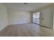 Bright living room featuring wood-style flooring, neutral walls, sliding glass doors, and an entry door at 413 N Lamb Blvd # E, Las Vegas, NV 89110