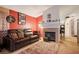 Living room includes a fireplace and a brown leather couch at 4314 Flaming Ridge Trl, Las Vegas, NV 89147