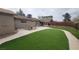 Spacious backyard with well-maintained artificial turf, patio and mature trees at 4512 Mark Ave, Las Vegas, NV 89108