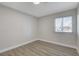 Bedroom with wood-look flooring, a window with blinds, and neutral paint, offering a serene and modern aesthetic at 4512 Mark Ave, Las Vegas, NV 89108