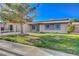 Inviting single-story home with a well-manicured lawn and mature tree in the front yard at 4512 Mark Ave, Las Vegas, NV 89108