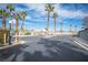 View of the community entrance, featuring a gate, mature palm trees, and well-maintained landscaping on a sunny day at 536 Roberta Alecia Ave, North Las Vegas, NV 89031