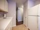 View of kitchen with access to hallway and featuring all white cabinetry and appliances at 536 Roberta Alecia Ave, North Las Vegas, NV 89031