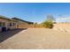 View of a low-maintenance gravel backyard, with a block wall and covered patio at 5468 Carrara Pointe St, Pahrump, NV 89061