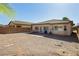 Low-maintenance backyard with gravel landscaping and block wall; covered patio with furniture at 5468 Carrara Pointe St, Pahrump, NV 89061