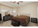 Neutral primary bedroom with a ceiling fan, large mirror, and ample natural light at 5468 Carrara Pointe St, Pahrump, NV 89061