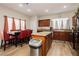 Well-lit kitchen featuring wood cabinets, a center island, and a dining area with red chairs at 5468 Carrara Pointe St, Pahrump, NV 89061