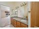 Dual sink bathroom with wood cabinets and a view into another room at 5625 W Agate Ave, Las Vegas, NV 89139