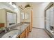 Bathroom with granite counters, double sinks, and a glass-enclosed shower at 5625 W Agate Ave, Las Vegas, NV 89139