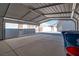 Open carport with a concrete slab, trash cans, and adjacent to a house at 5625 W Agate Ave, Las Vegas, NV 89139