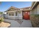 Charming front entrance featuring a red door, a red tile roof, and manicured landscaping at 5625 W Agate Ave, Las Vegas, NV 89139