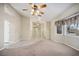 Open living room with ceiling fan, tile and carpet flooring, and direct access to the front door at 5625 W Agate Ave, Las Vegas, NV 89139