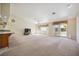 Large, bright living room with beige carpet, ceiling fan and sliding door access to the backyard at 5625 W Agate Ave, Las Vegas, NV 89139