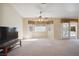 Large living room with carpet, windows, tv, and sliding door to the back at 5625 W Agate Ave, Las Vegas, NV 89139