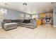 Open-concept living room featuring tile flooring and a large, comfortable gray sectional sofa at 6356 Blue Twilight Ct, Las Vegas, NV 89108