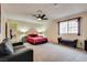 Large bedroom with red bedding, black furniture, and a ceiling fan at 6520 Brushwood Ln, Las Vegas, NV 89107