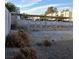 Fenced backyard with gravel landscaping, block wall, and covered parking structure at 6741 Solaron Ave, Las Vegas, NV 89156