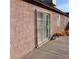 View of the stucco exterior of the home, with sliding door and window at 6741 Solaron Ave, Las Vegas, NV 89156