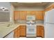 Kitchen featuring light oak cabinets, white appliances, and tile flooring at 700 Carnegie St # 3711, Henderson, NV 89052