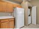 Kitchen with light wooden cabinets and white appliances with a laundry closet at 700 Carnegie St # 3711, Henderson, NV 89052