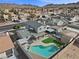 An aerial view of a home with a pool and mountain views, set in a peaceful residential neighborhood at 714 Arrowhead Trl, Henderson, NV 89002