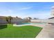 Private backyard with a swimming pool, artificial grass, and mature palm trees at 714 Arrowhead Trl, Henderson, NV 89002