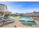 A backyard showcasing a pool with a built-in spa, lounge chairs, and a covered patio area, ideal for relaxation at 714 Arrowhead Trl, Henderson, NV 89002