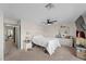 Bright bedroom with ceiling fan, carpet, white bedding, and white dresser at 714 Arrowhead Trl, Henderson, NV 89002