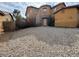 Two story home featuring a stone archway, stucco siding and a rock-covered front yard at 7511 Shadow Estates Way, Las Vegas, NV 89113