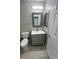 Stylish bathroom featuring a gray vanity with a framed mirror, white countertop, toilet, and wood-look flooring at 7732 Hand Woven Ct, Las Vegas, NV 89149