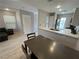 Open concept dining area with sleek floors, modern table, and living room in background at 7732 Hand Woven Ct, Las Vegas, NV 89149