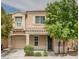 Two-story house with tan siding, a dark-gray door, and a well-manicured lawn at 7732 Hand Woven Ct, Las Vegas, NV 89149