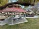 Community park featuring picnic tables under a covered structure and a playground in the background at 7732 Hand Woven Ct, Las Vegas, NV 89149