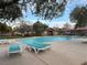 Community pool featuring lounge chairs around the pool, with trees providing shade at 7732 Hand Woven Ct, Las Vegas, NV 89149