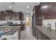 Kitchen with dark cabinets, granite countertops and stainless steel appliances at 825 Great Sky Ct, North Las Vegas, NV 89084