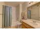 Well-lit bathroom with a shower-tub combo with blue shower curtain and a vanity with sink at 9070 Spring Mountain Rd # 113, Las Vegas, NV 89117