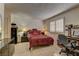 Bright bedroom features a red patterned bedspread, window with blinds, carpet floors and dark furniture at 9070 Spring Mountain Rd # 113, Las Vegas, NV 89117