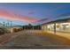 Backyard featuring a lawn and retaining wall, patio, and sunset sky at 1044 Geranium Dr, Henderson, NV 89011