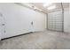 View of a large garage with white walls, concrete floors, garage door, and a utility door at 1044 Geranium Dr, Henderson, NV 89011