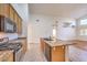 Bright kitchen features granite countertops, wood cabinets, stainless steel appliances and center island with black sink at 1056 Flatfoot Ave, Henderson, NV 89012