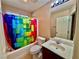 Bathroom with vibrant shower curtain, tile floor, and single sink vanity at 10840 Holmfield St, Henderson, NV 89052