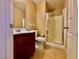 Bathroom featuring tile floors, single sink vanity, shower stall, and a linen closet at 10840 Holmfield St, Henderson, NV 89052