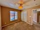 Cozy bedroom with neutral paint, carpet, standard ceiling fan, shuttered windows, and closet at 10840 Holmfield St, Henderson, NV 89052