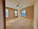 A cozy bedroom featuring carpeted floors, a ceiling fan, and shuttered windows at 10840 Holmfield St, Henderson, NV 89052