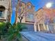 Charming townhome with a two-car garage and well-maintained landscaping, beneath a bright blue sky at 10840 Holmfield St, Henderson, NV 89052