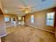 Open living room with carpeted area and tiled area, featuring a ceiling fan and shutters at 10840 Holmfield St, Henderson, NV 89052
