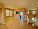 Open floor plan living room with tiled floor, open breakfast bar, staircase and natural light at 10840 Holmfield St, Henderson, NV 89052