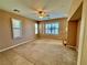 Living room featuring carpeted floors, a ceiling fan, and several shuttered windows at 10840 Holmfield St, Henderson, NV 89052