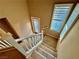 An interior shot of a carpeted staircase with white wooden banister and sunlit window at 10840 Holmfield St, Henderson, NV 89052